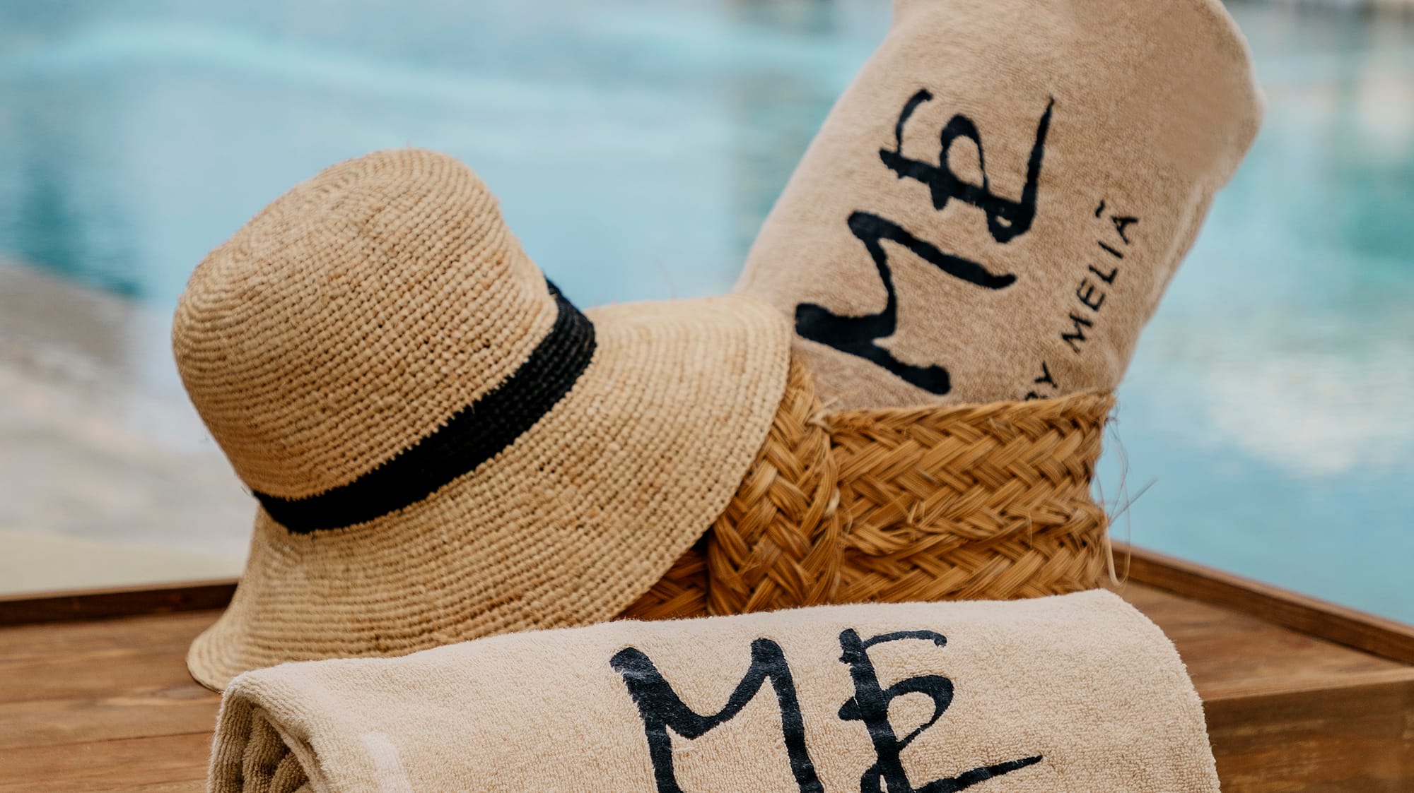 a towel and hat on a tray by a pool