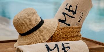 a towel and hat on a tray by a pool