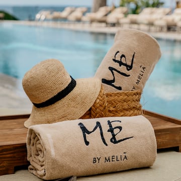 a towel and hat on a tray by a pool