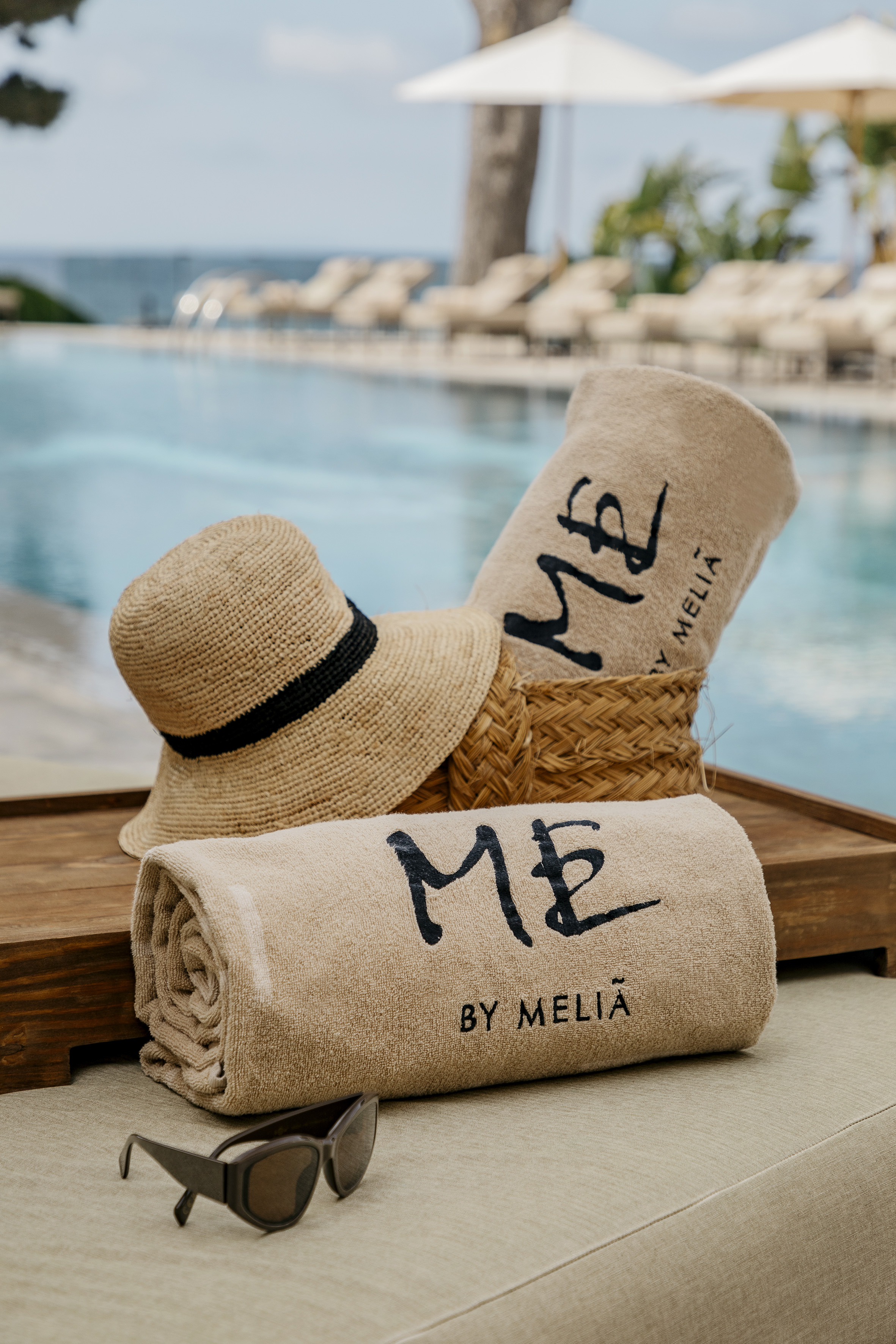 a towel and hat on a tray by a pool