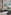 Spacious hotel lobby with modern lounge seating, glass elevators, and orchids.