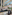 Spacious hotel lobby with modern lounge seating, glass elevators, and orchids.
