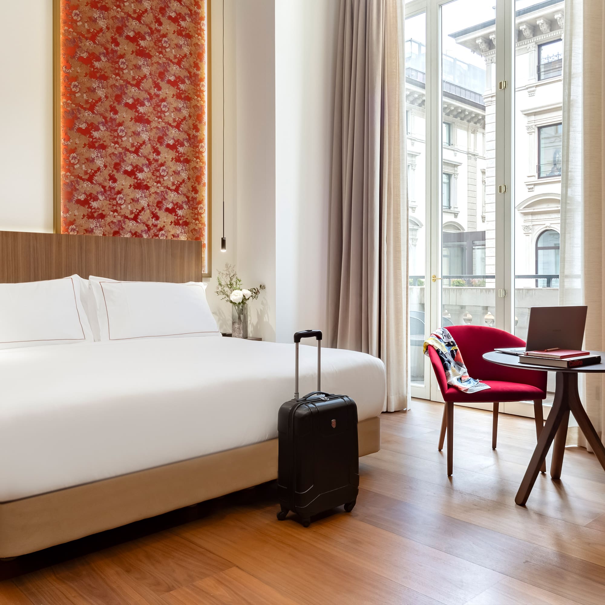 a room with a bed and a chair and a laptop