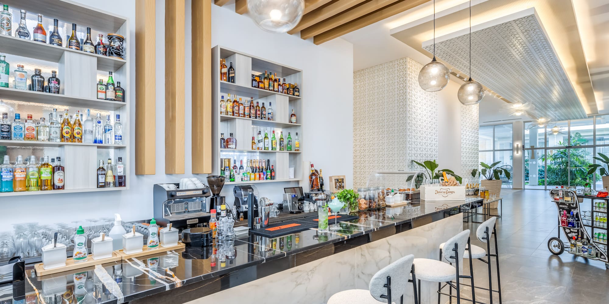 a bar with stools and bottles
