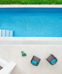 a pool with chairs and a lawn