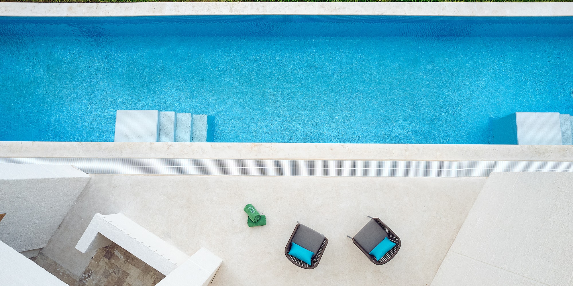 a pool with chairs and a lawn