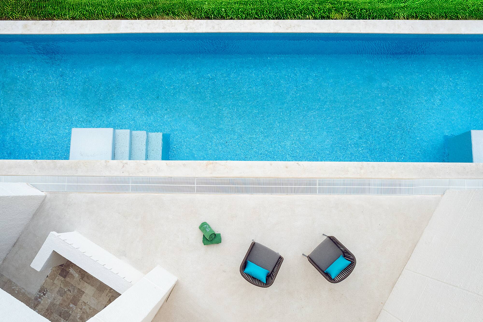 a pool with chairs and a lawn
