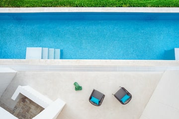 a pool with chairs and a lawn