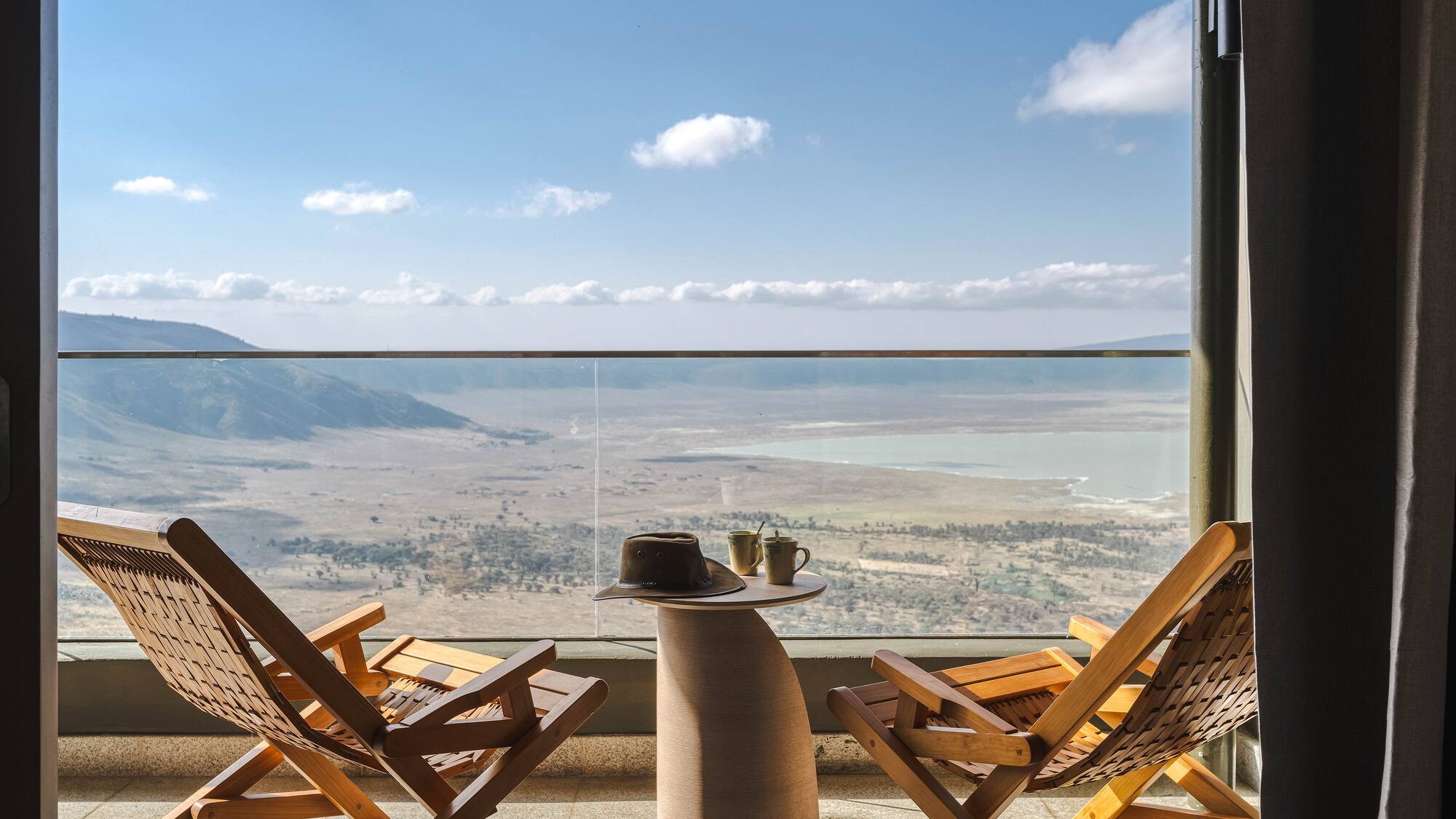 a chair and table with a view of the mountains and a valley