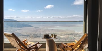 a chair and table with a view of the mountains and a valley