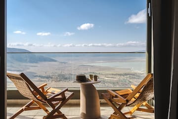 a chair and table with a view of the mountains and a valley