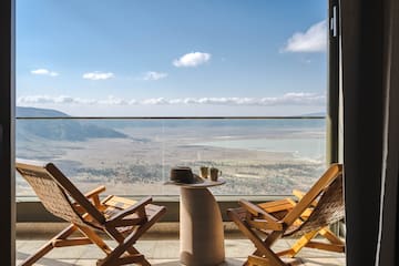 a chair and table with a view of the mountains and a valley