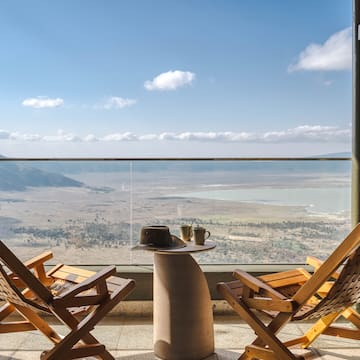 a chair and table with a view of the mountains and a valley