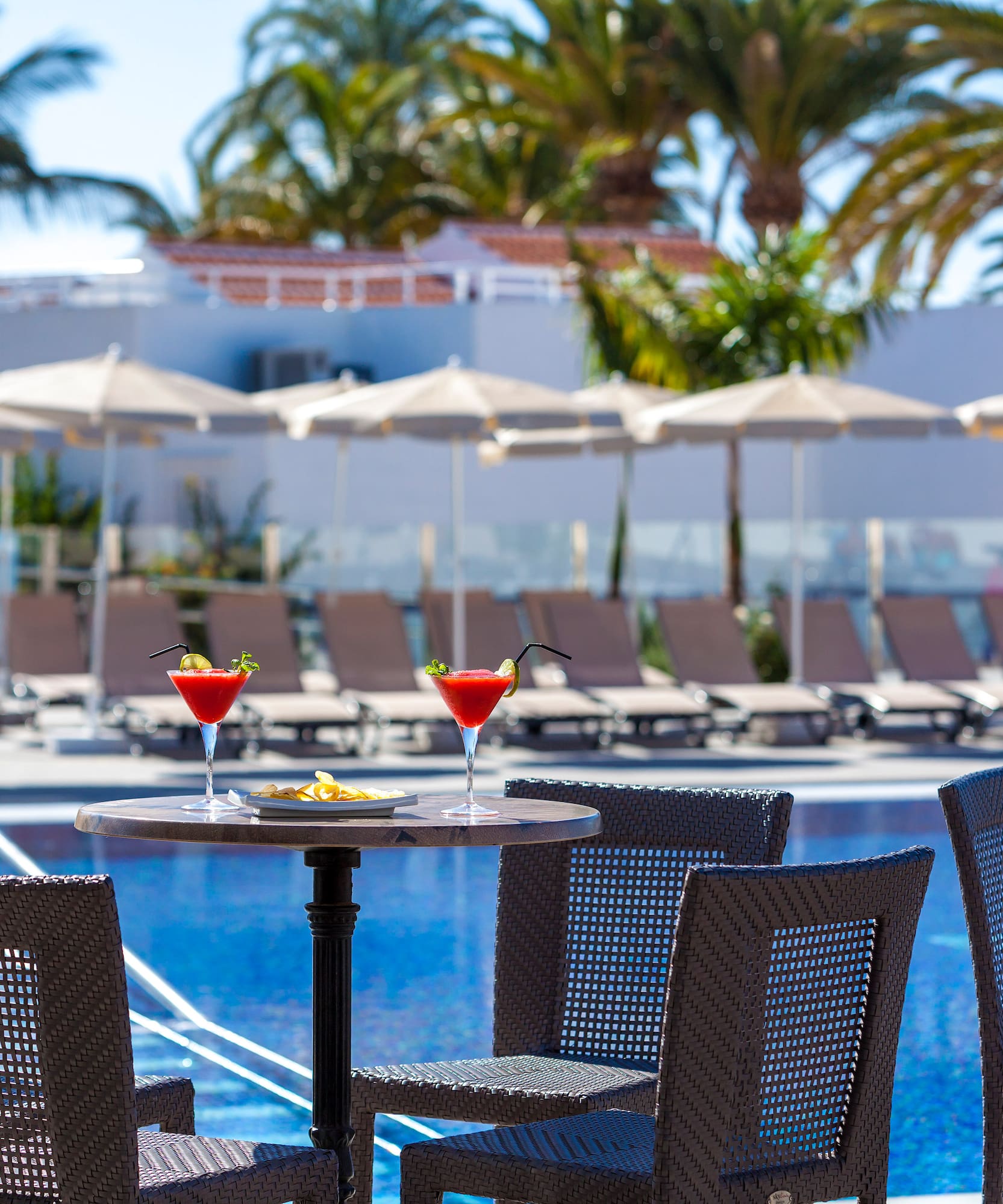 a table with drinks on it by a pool