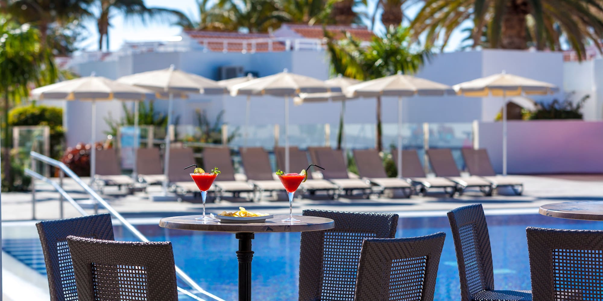 a table with drinks on it by a pool