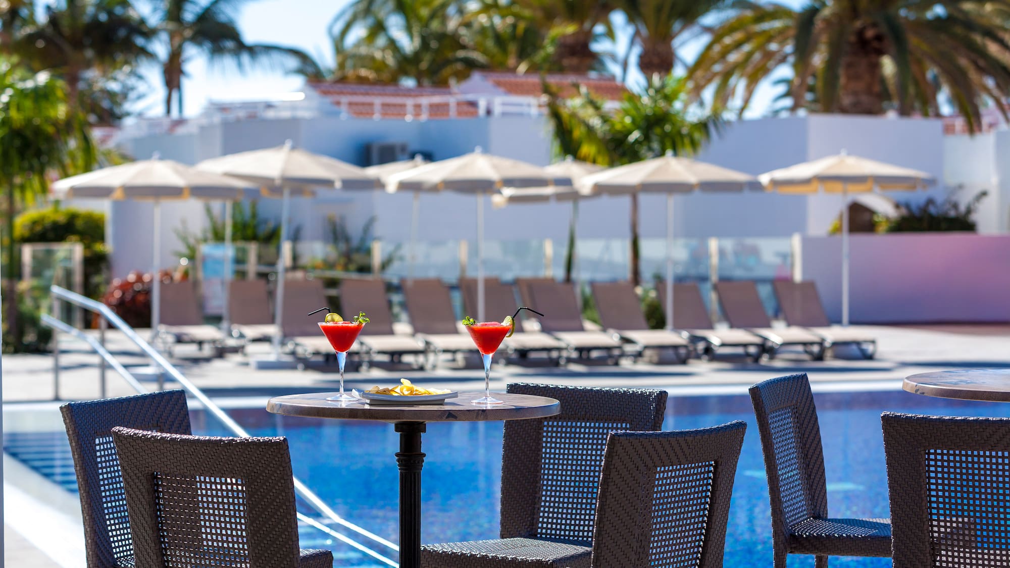 a table with drinks on it by a pool