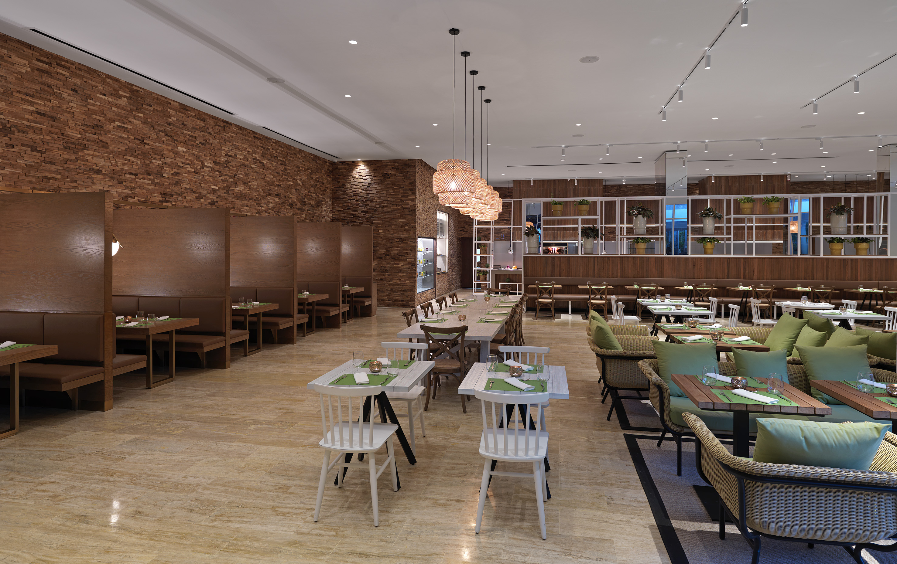 Spacious modern restaurant interior with booth and table seating, wood walls.