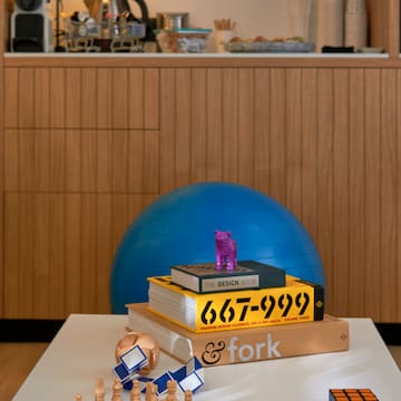 a table with a stack of books and a blue ball