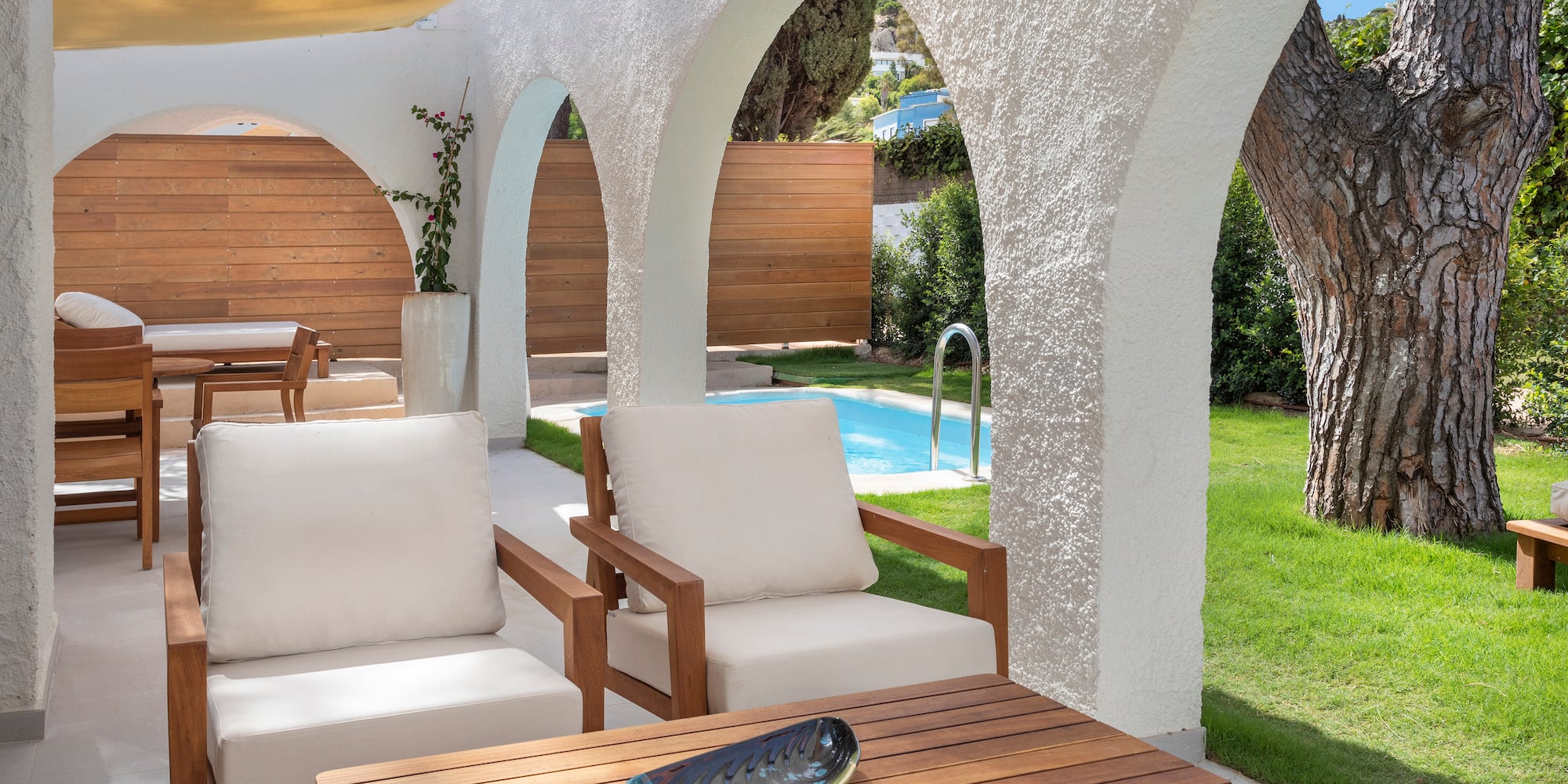 a patio with white chairs and a table