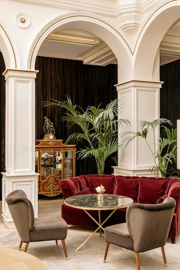 a room with a red couch and chairs