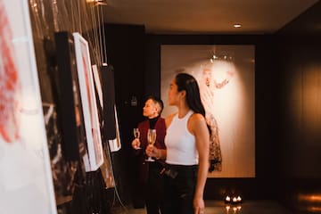 a man and woman looking at pictures on the wall