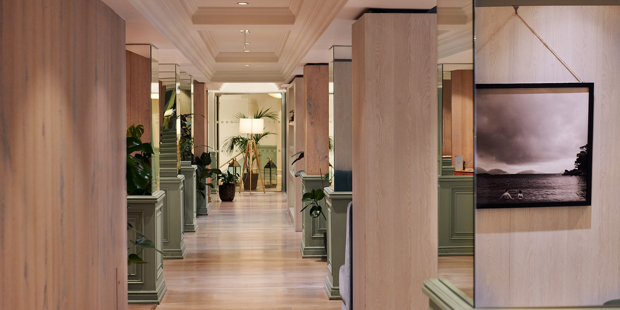 a hallway with a wood floor and green walls