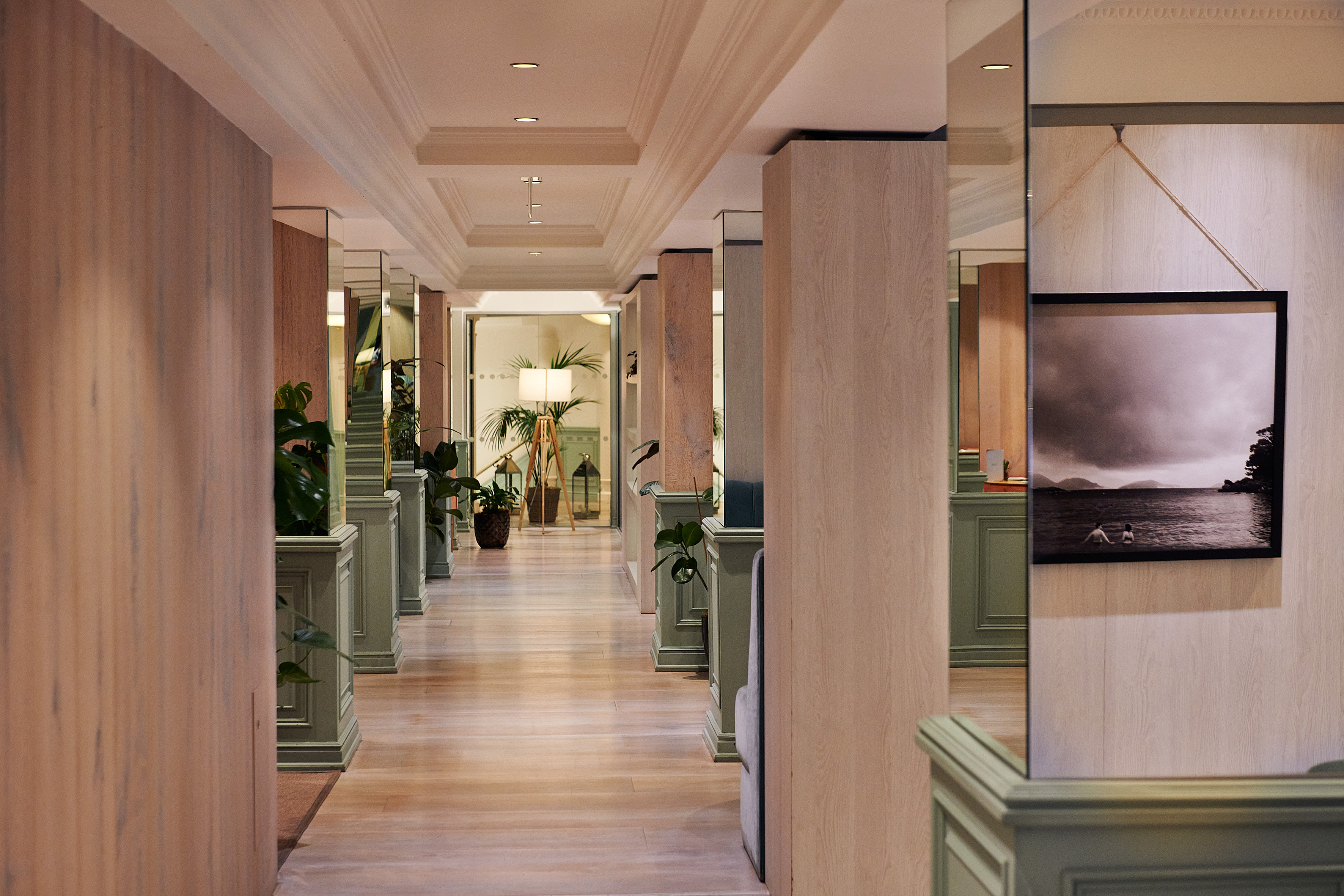 a hallway with a wood floor and green walls