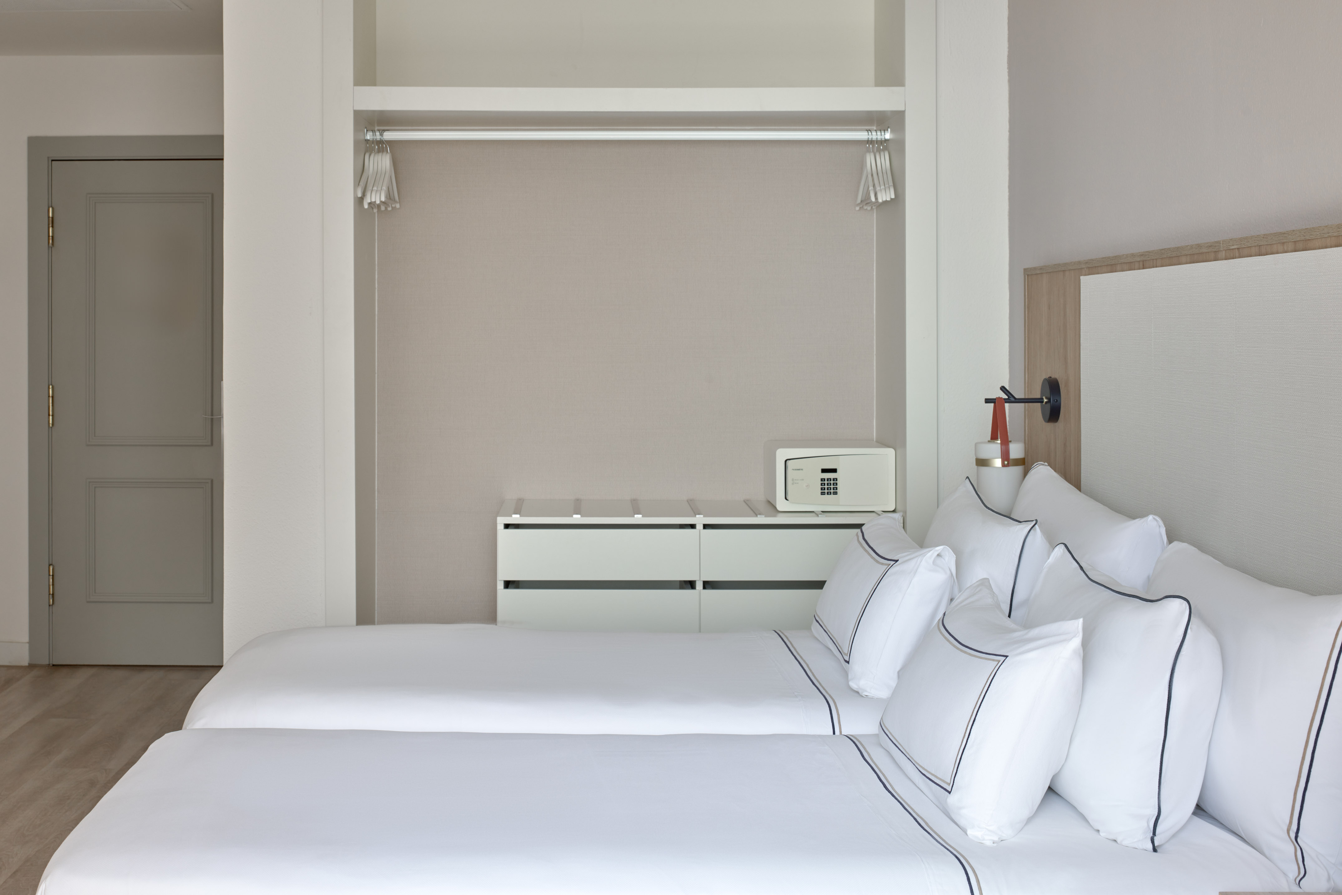 Clean hotel room with twin beds, built-in closet, and personal safe.