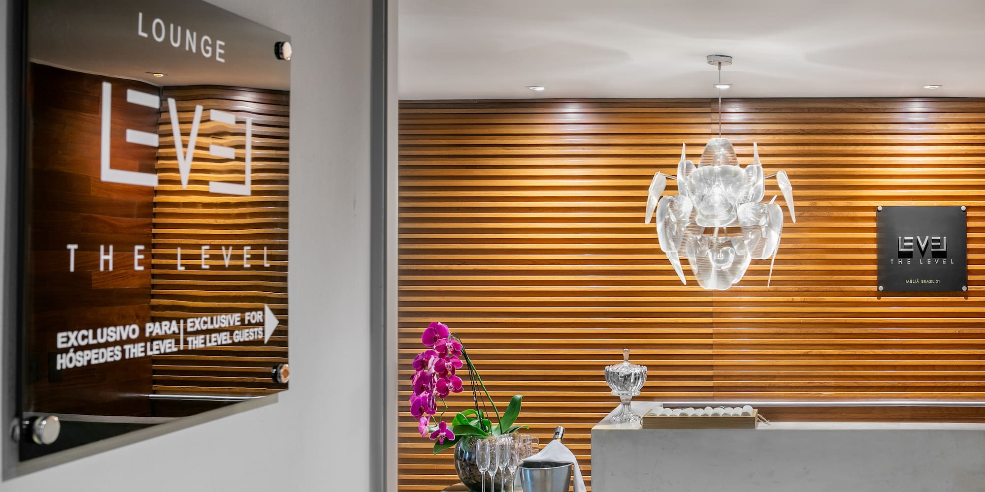 Hotel "The Level" lounge entrance, modern reception with orchids and chandelier.