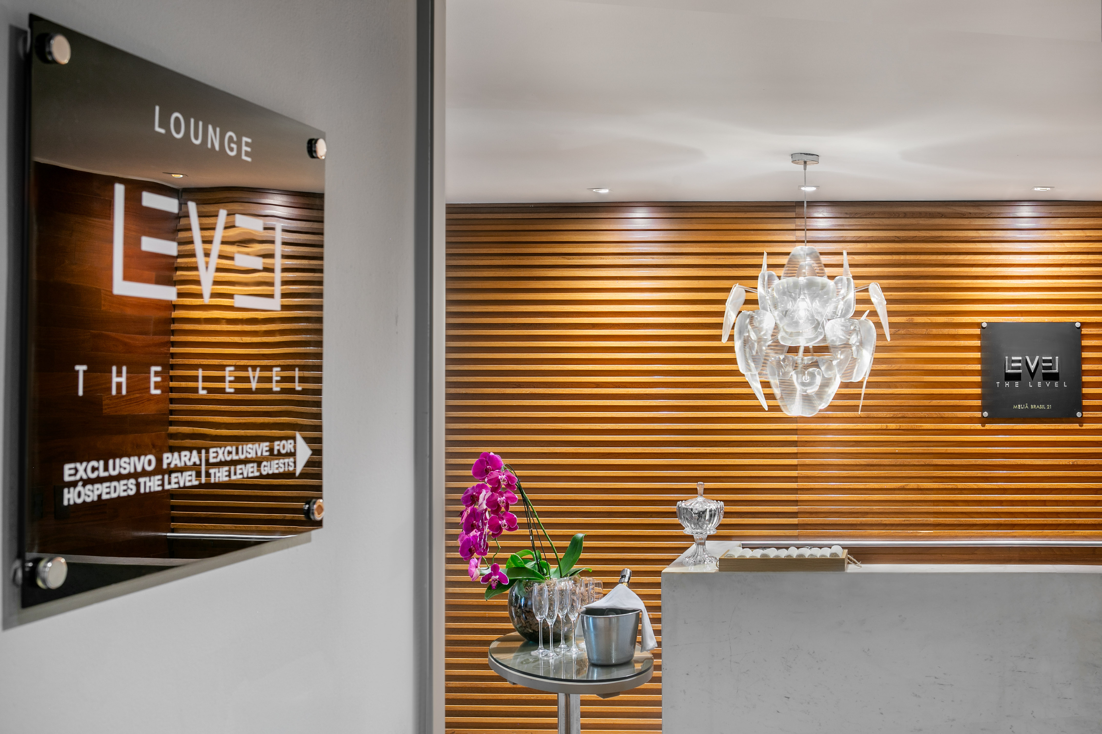 Hotel "The Level" lounge entrance, modern reception with orchids and chandelier.