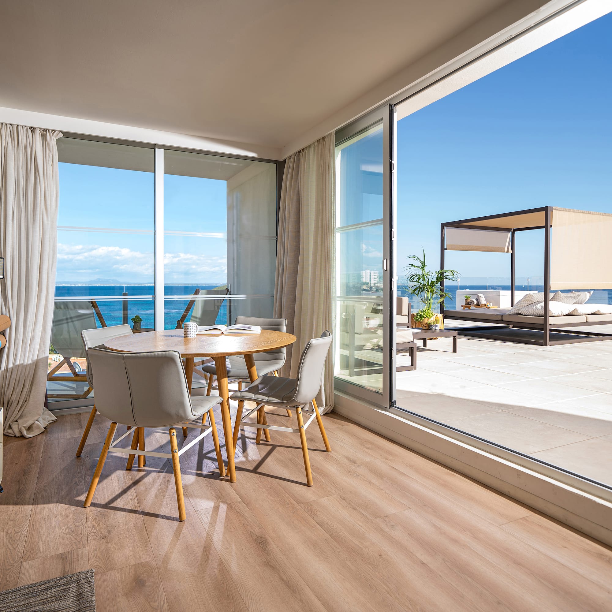 a room with a table and chairs and a large glass door