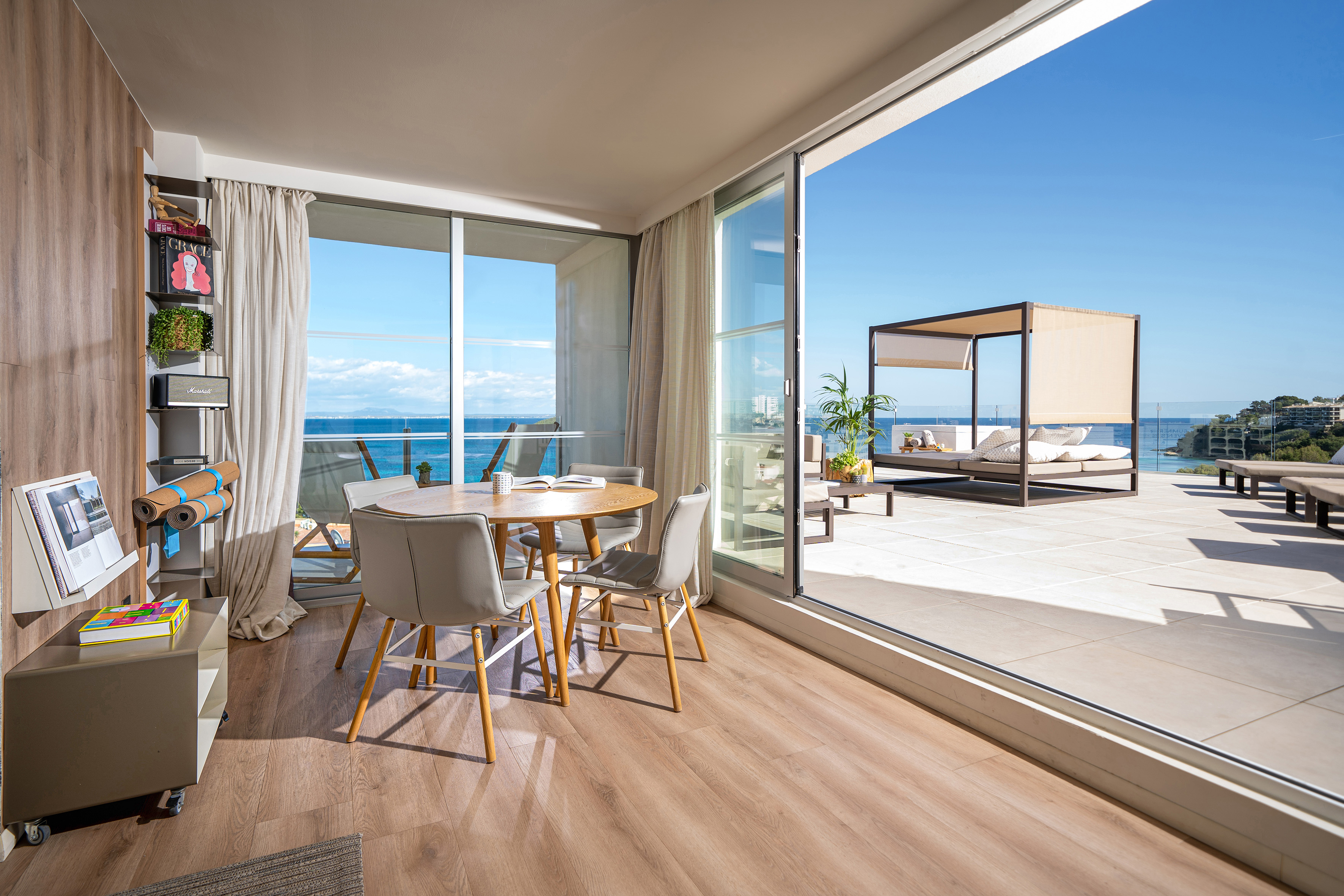 Luxury ocean view apartment: indoor dining, outdoor terrace with daybed.