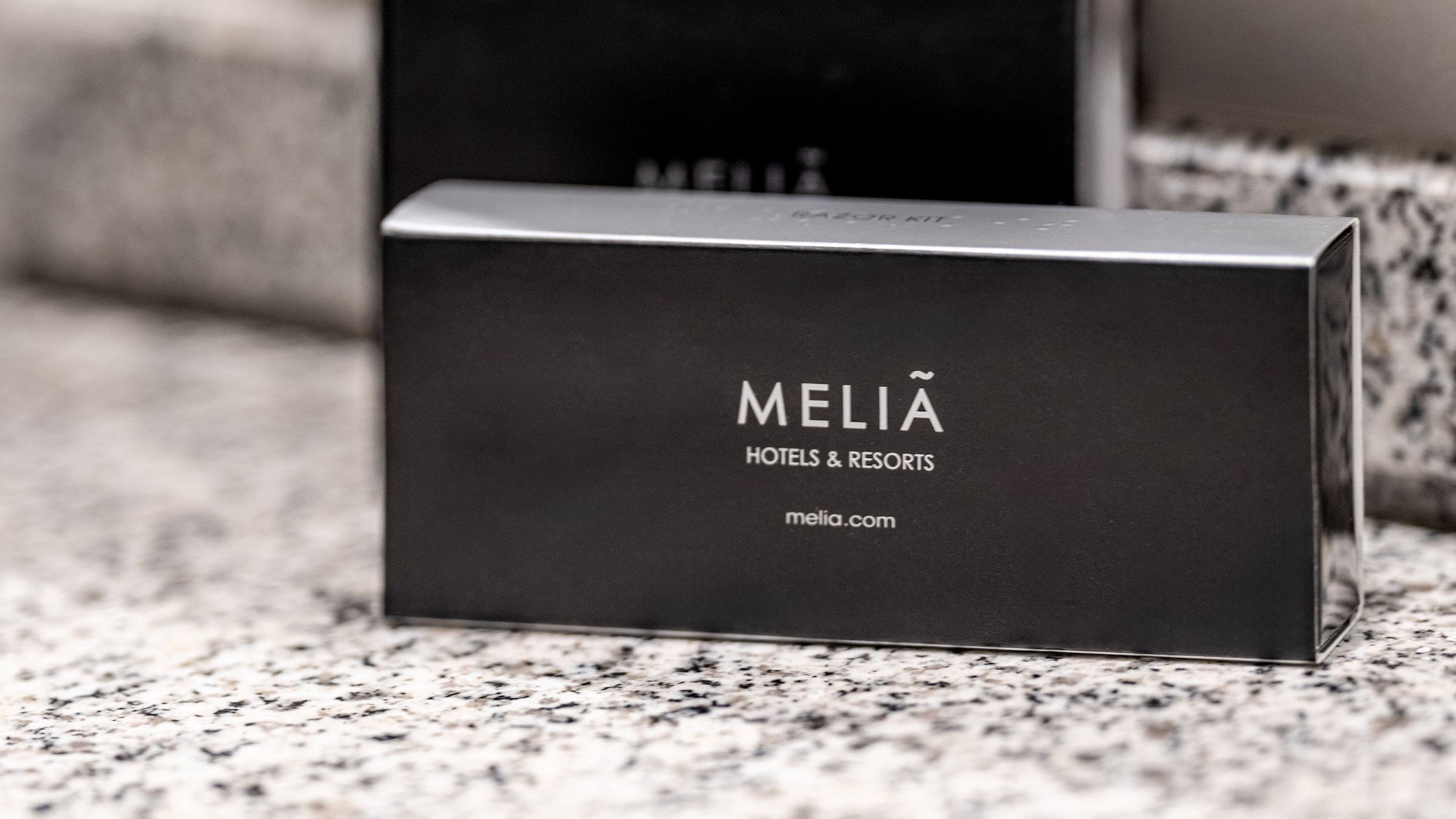 Black Melia Hotels & Resorts razor kit amenity on granite.