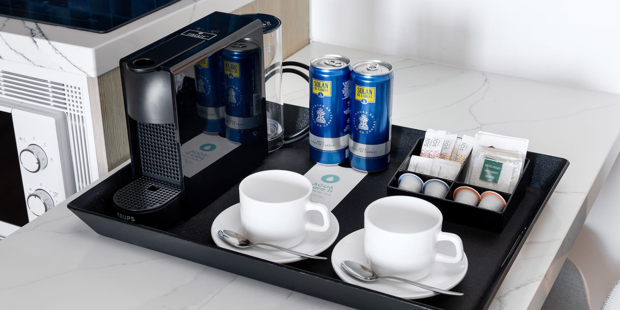 a tray with coffee and tea cups and cans