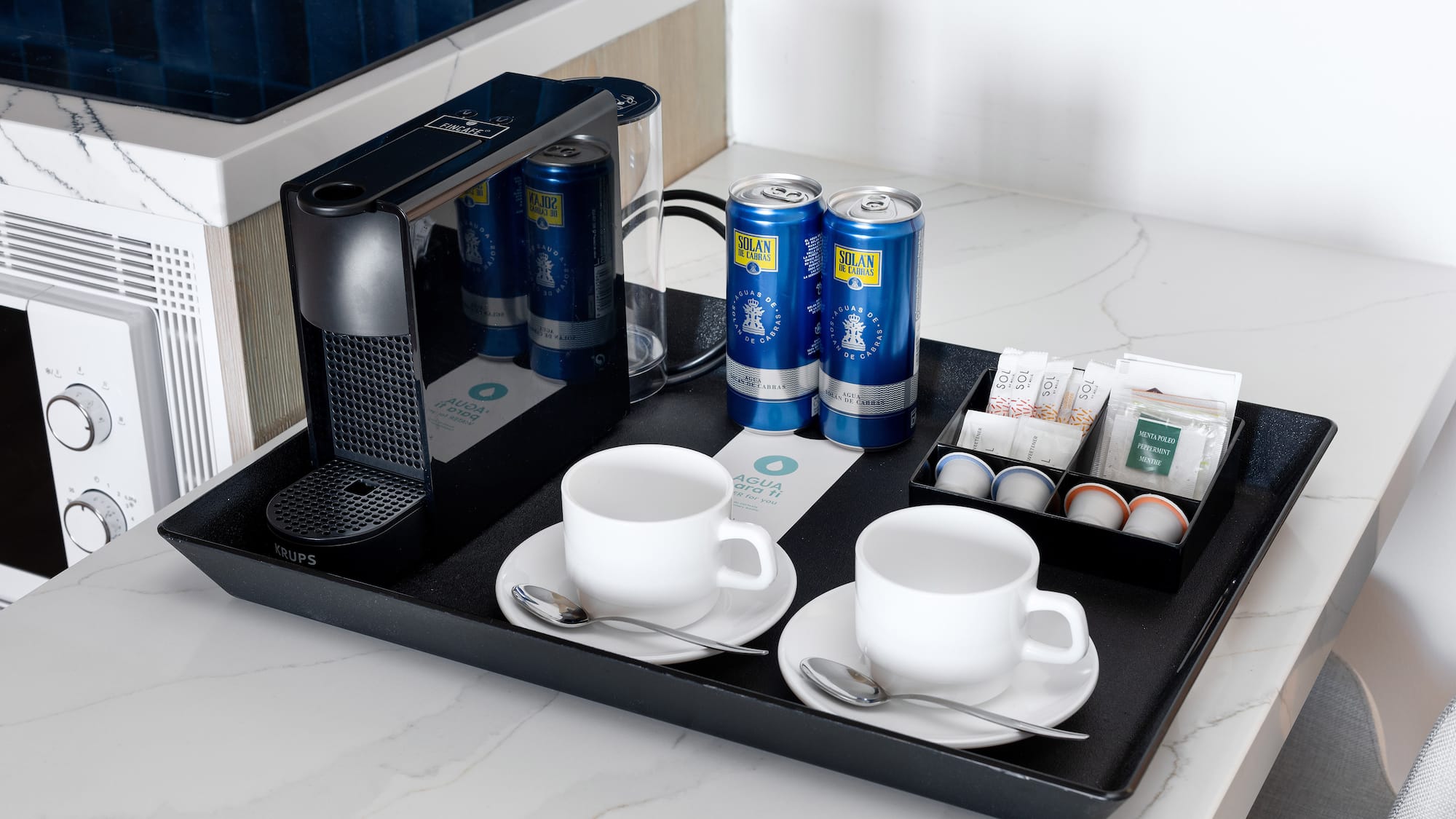 a tray with coffee and tea cups and cans
