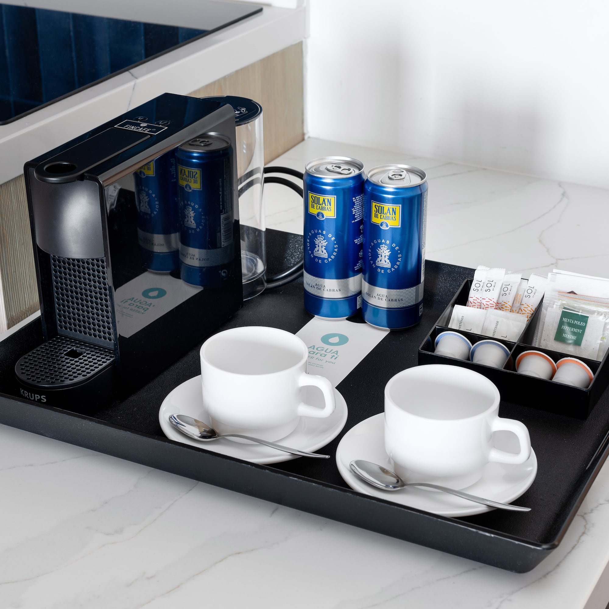 a tray with coffee and tea cups and cans