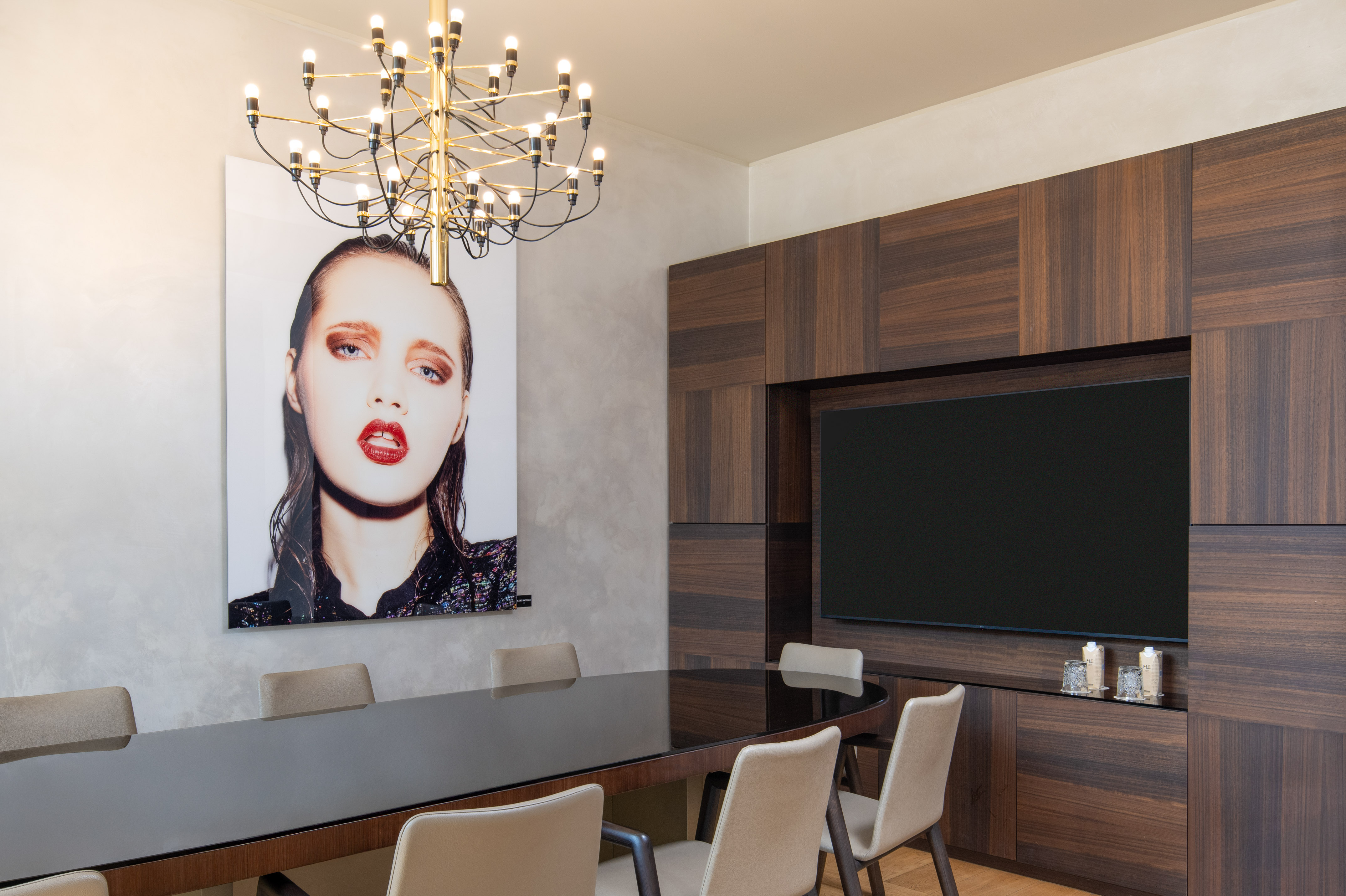 Modern conference room with wood paneling, large TV, and modern art.