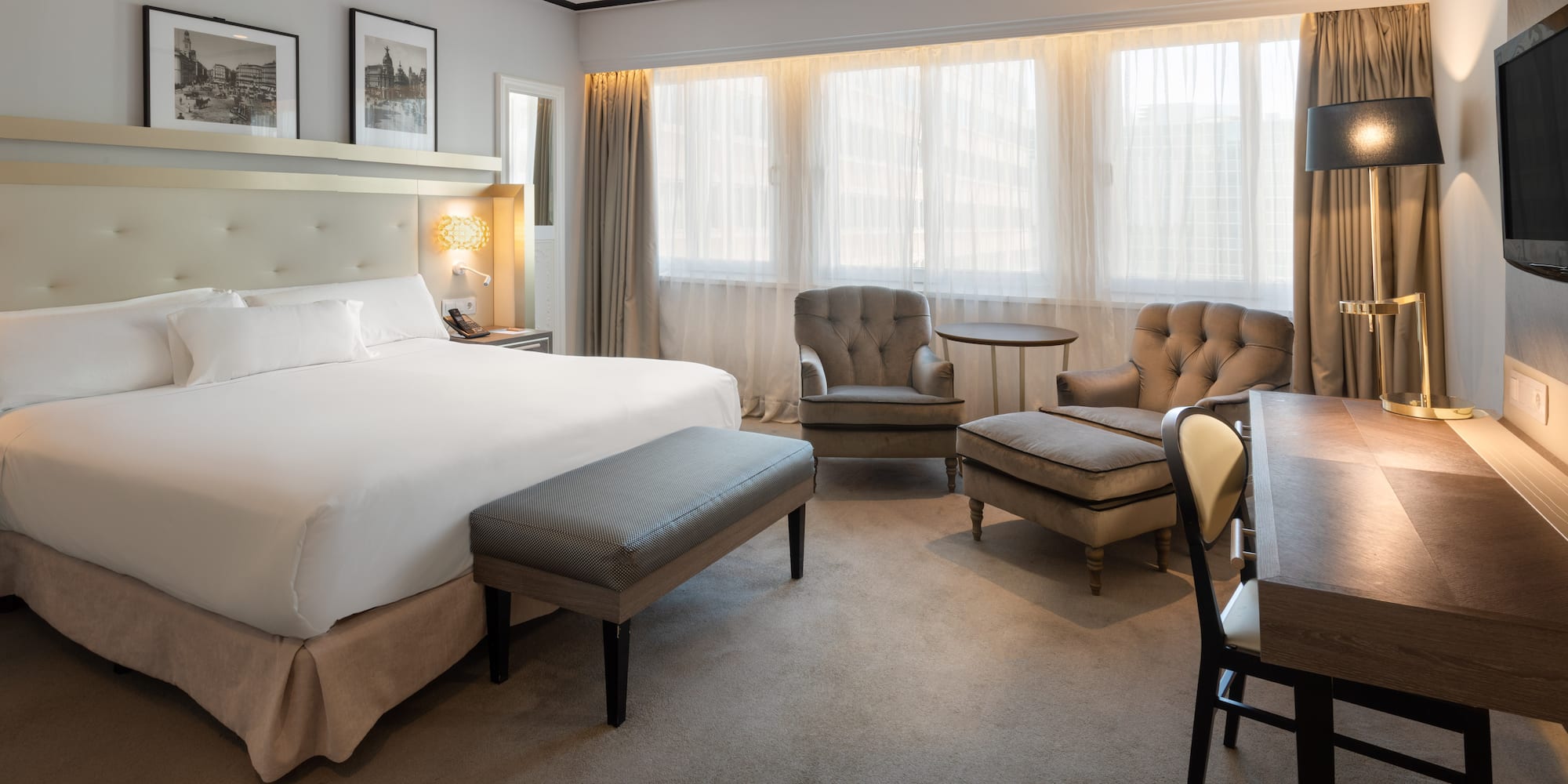 a room with a bed and chairs