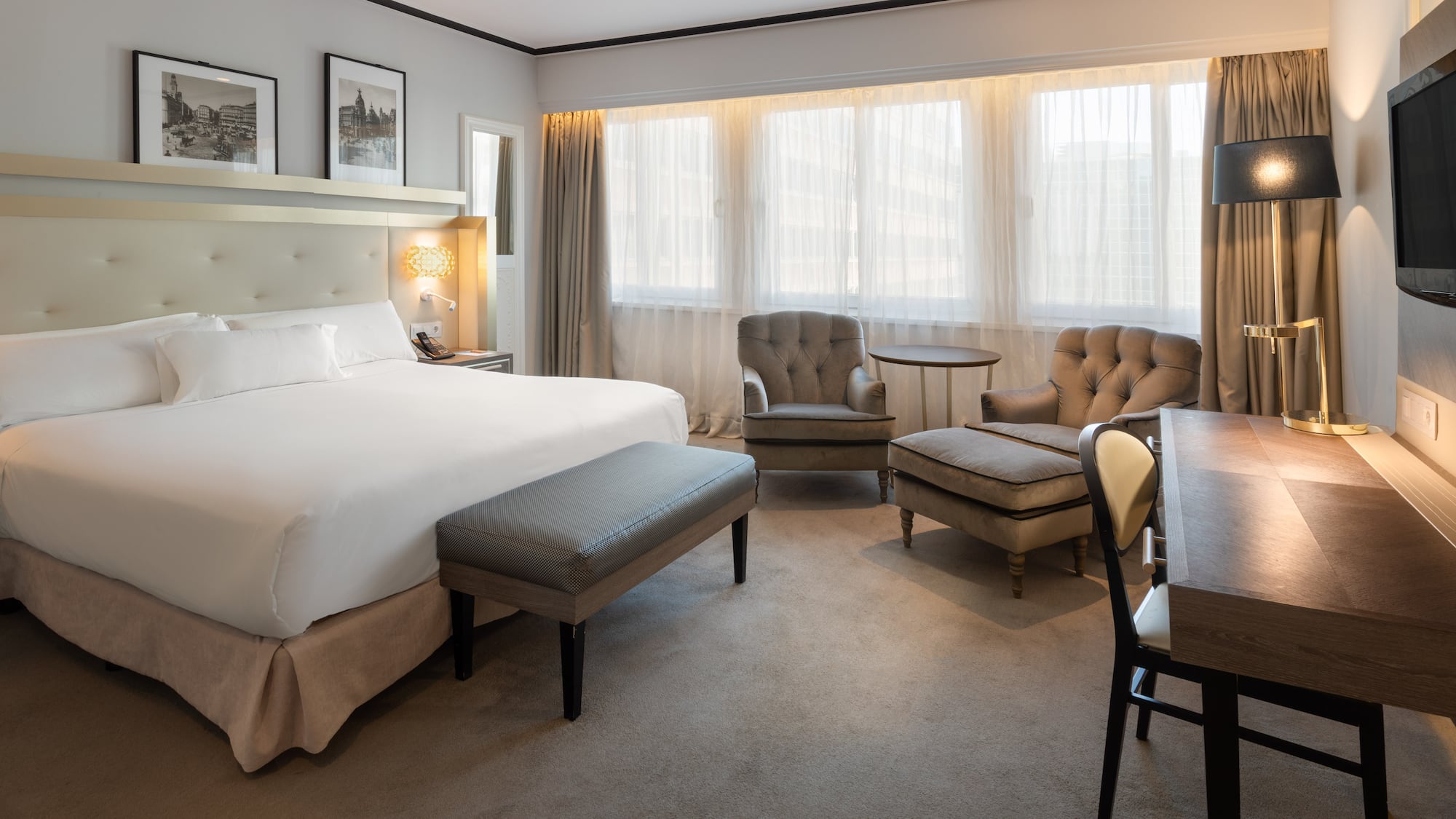 a room with a bed and chairs