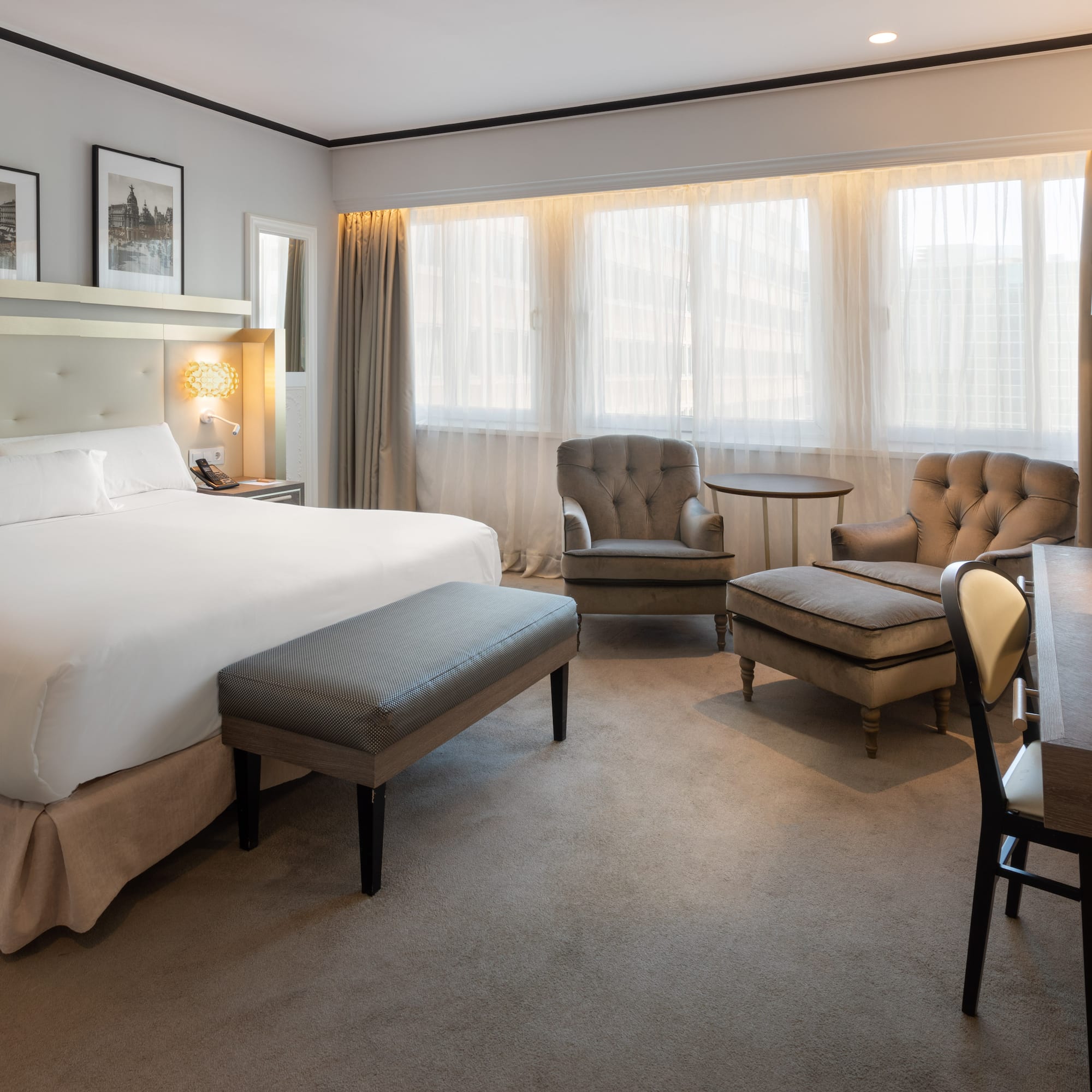 a room with a bed and chairs