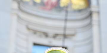 a hand holding a cup of green liquid