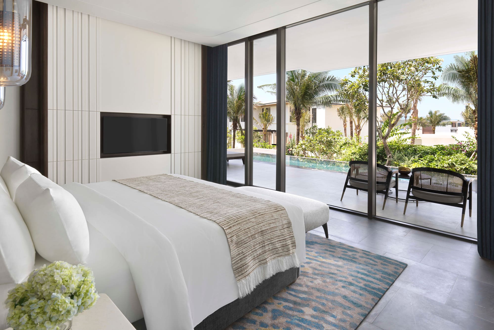 a bedroom with a large glass wall and a television