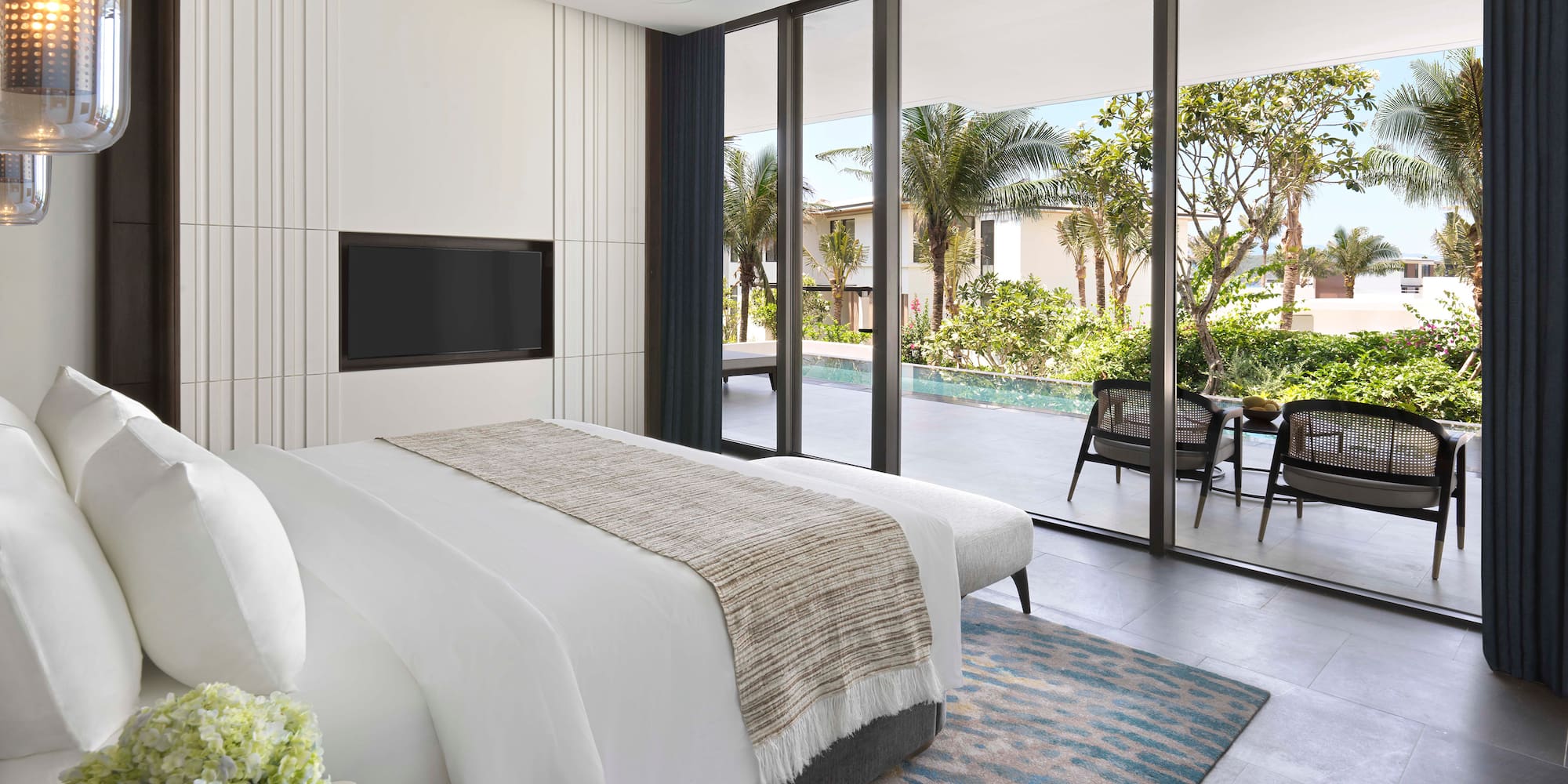 a bedroom with a large glass wall and a television