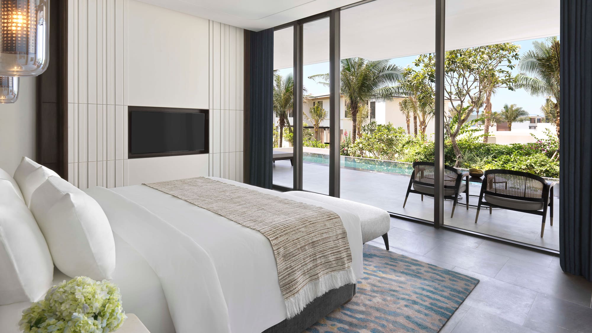 a bedroom with a large glass wall and a television