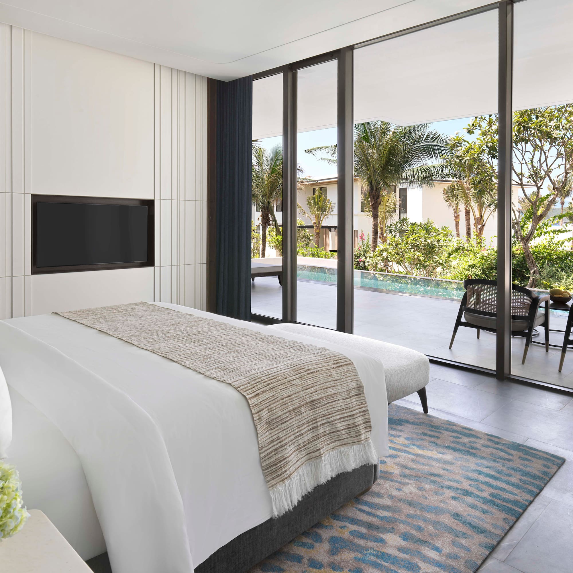 a bedroom with a large glass wall and a television