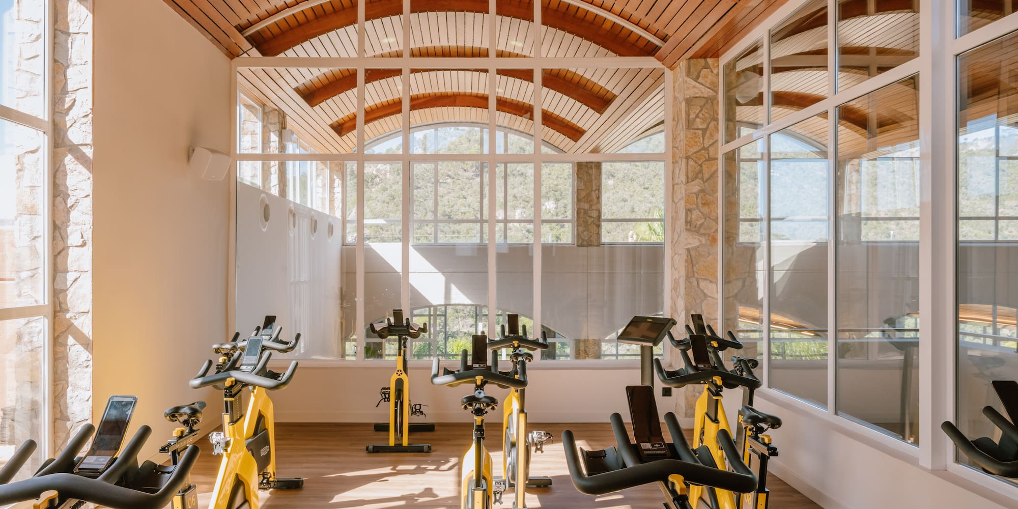 a room with exercise bikes and a wood floor