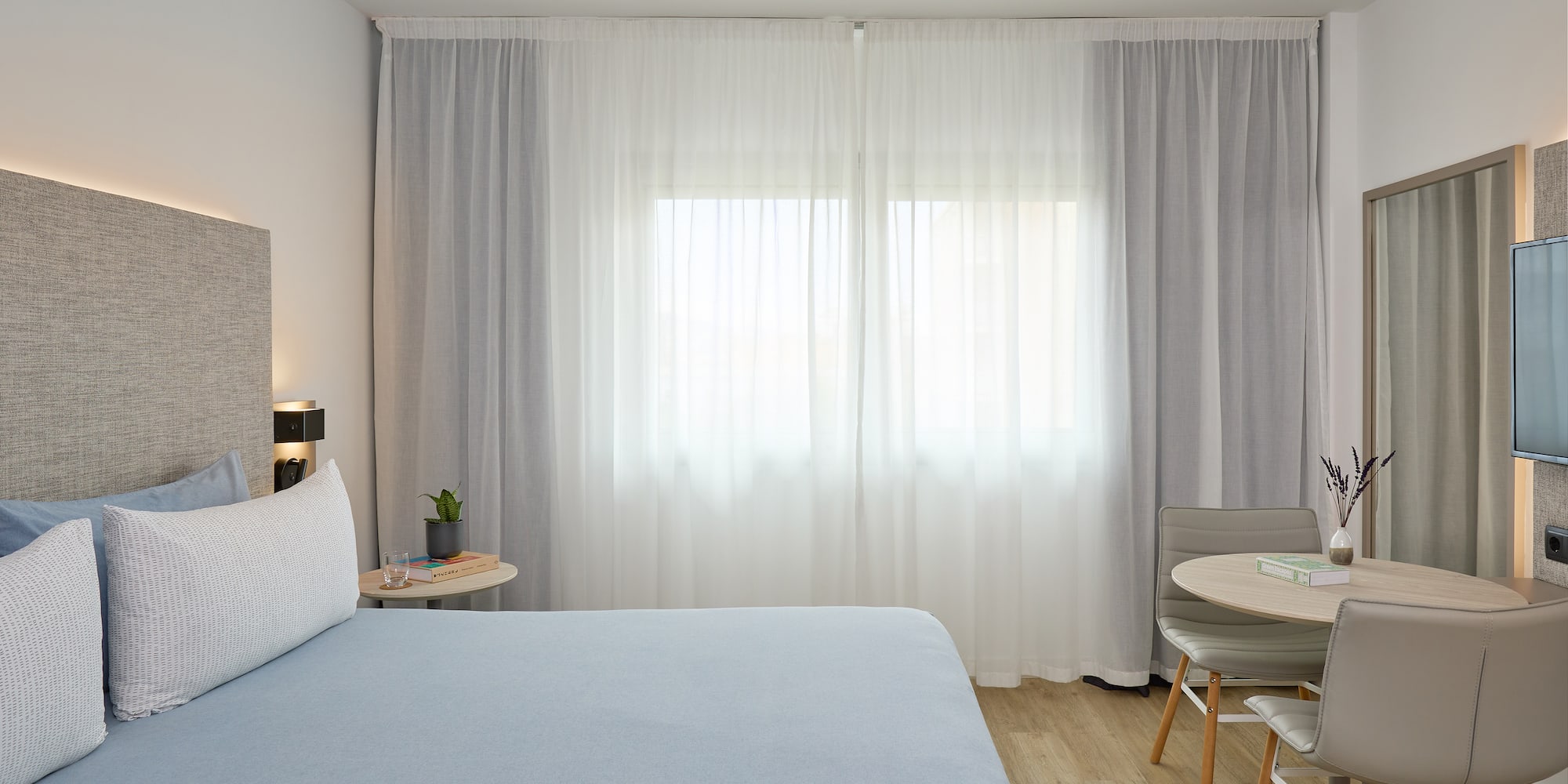 a bedroom with a bed and a table and chairs