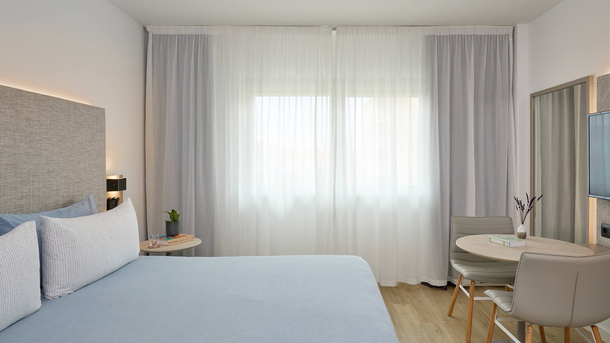 a bedroom with a bed and a table and chairs