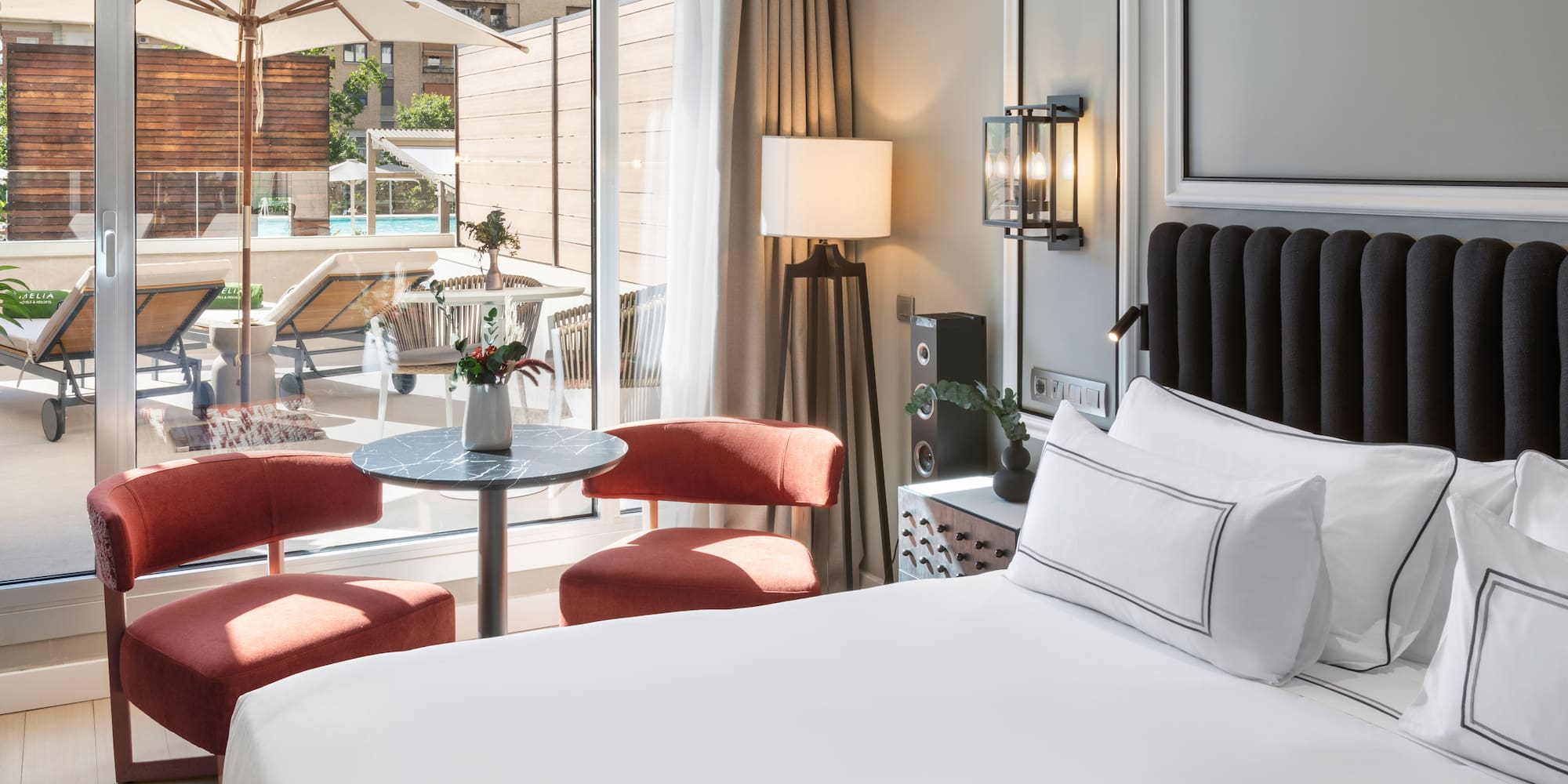 a room with a bed and chairs