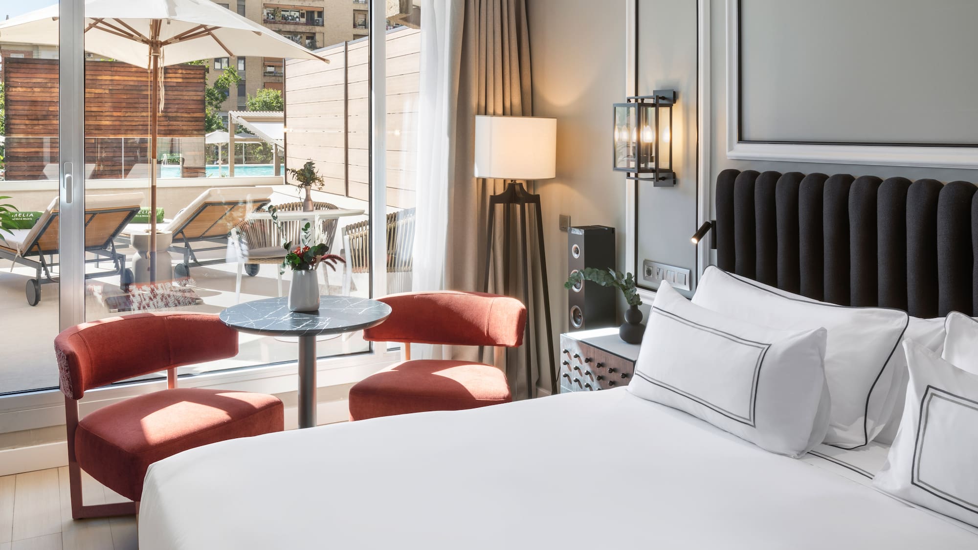 a room with a bed and chairs